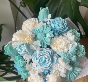 Bouquet de bougies artisanales bleues et blanches en cire végétale, façonnées comme des fleurs.