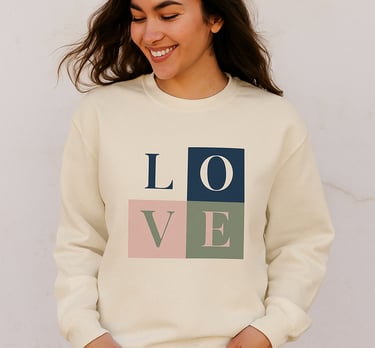 Lächelnde Frau trägt cremefarbenes Sweatshirt mit großem LOVE-Blockdesign auf der Vorderseite
