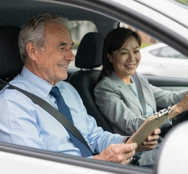 A friendly instructor guiding a teen driver through a quiet neighborhood street.