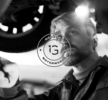 Foto de mecánico en blanco y negro con el logotipo de Góngora Motorworks en primer plano