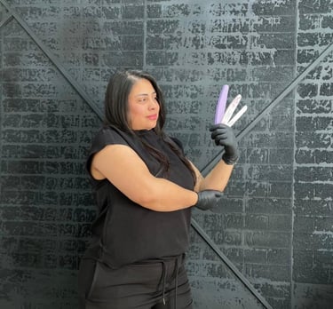 a woman in black top and gloves holding a purple hairbrush