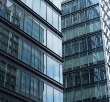 Abstract shot of modern architecture with glass and steel in shades of sky blue and navy blue, reflecting clarity and structural integrity.