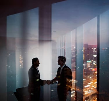 Two business professionals shaking hands in a high-rise office overlooking a city skyline at sunset.