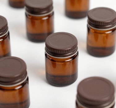 A collection of natural and synthetic candle fragrances in small bottles.