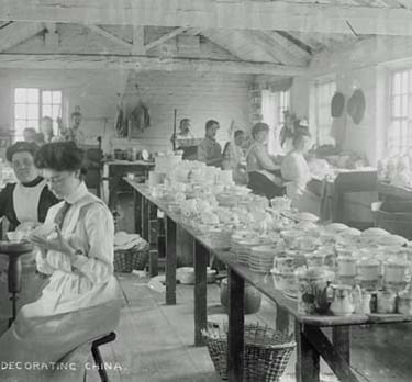 Vintage black and white photo of women workers decorating fine china in a 19th-century pottery factory.