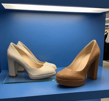 A vibrant display of women’s office shoes in fresh spring colors arranged neatly on a wooden shelf