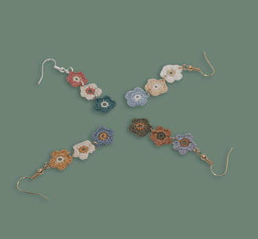 a group of earrings with crochet flowers