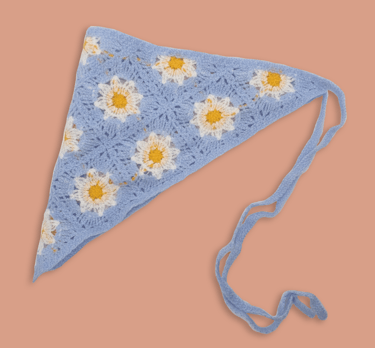 a blue crochet head scarf with flowers on it