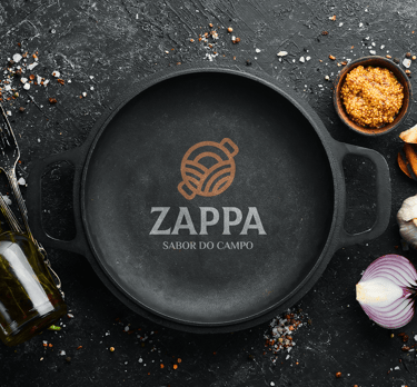 rustic metal pan with applied Zappa logo and seasonings under a table