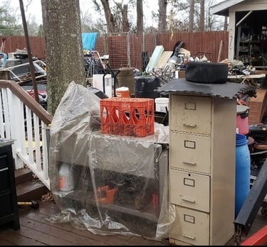 A yard filled with an overwhelming amount of junk. Old office furniture, tools, bed frames, etc.