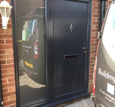 modern composite door with side panel and reflective glass.  the door has chrome hardware