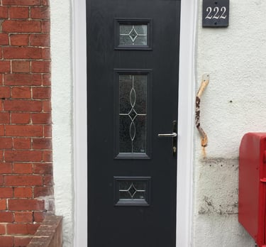 a thin front door fitted on a terrace house in Portsmouth by buildmydoor. black Dorn with pattern glass.