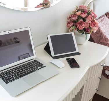 TechAid spec laptop computer sitting on a desk with a vase of flowers