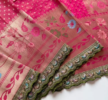 Elegant pink and mauve Banarasi silk saree with floral embroidery and a green scalloped border.