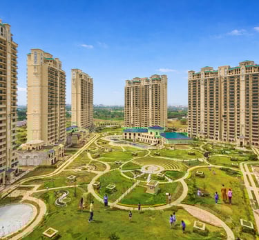 Luxury residential high-rise apartment complex featuring a landscaped courtyard with walking paths and green spaces.