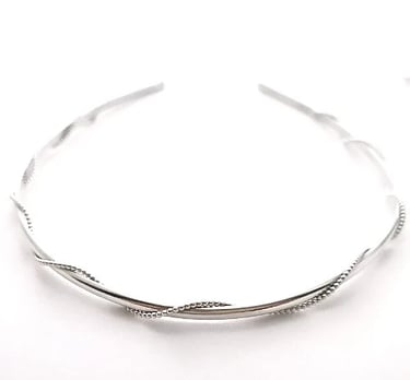 Elegant silver twisted headband with beaded wire detail on a white background.