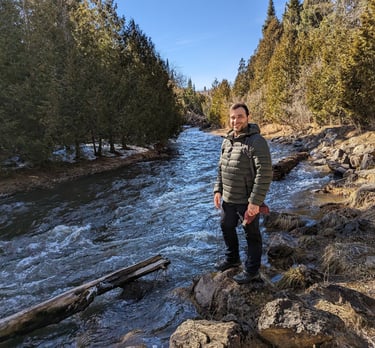 a man standing on a rocky river bank