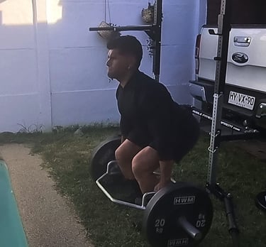 Cliente en peso muerto con barra hexagonal. Personal trainer a domicilio en La Reina.