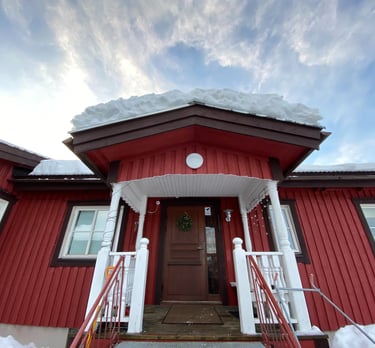 a red house with a red door and white stairs