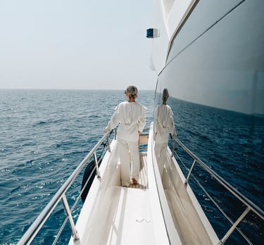 Девушка в белом смотрит на спокойное море с борта моторной яхты, аренда чхт