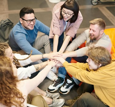 a group of people sitting around a group of people holding hands