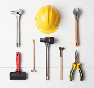 A close-up of a sturdy multi-tool with various attachments laid out on a wooden surface.