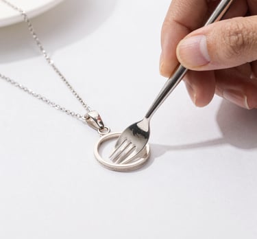 Hands gently cleaning silverware with a soft cloth and silver cleaner.