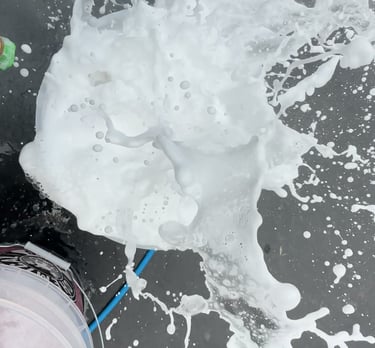 mobile detailing bucket showing foam splashing as a sponge falls in to water