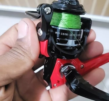 molinete pequeno albatroz para lambari mao segurando o molinete vermelho com preto