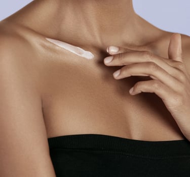 black woman applying shea butter to her shoulder