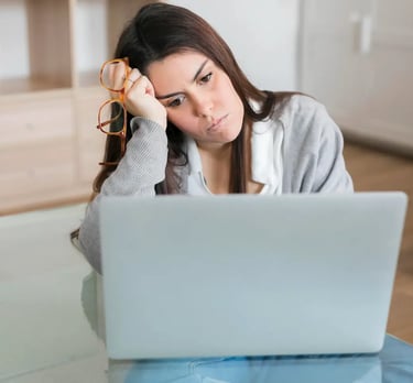 Emprendedora frustrada mirando su computador, representando el agobio de gestionar anuncios en redes