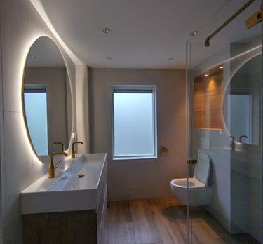 Moderne badkamer met een dubbele wasbak, gouden kranen en een inloopdouche.