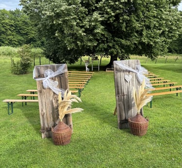 Cérémonie laïque dans un pré sous un chêne, bancs, porte et décoration champêtre pour cérémonie symbolique