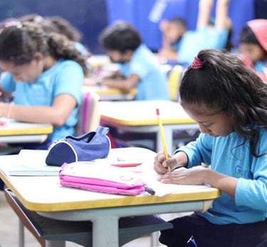 imagem mostra uma menina em sala de aula estudando