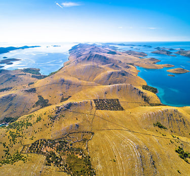 Aerial view of Kornati National Park archipelago with rocky islands and clear blue sea.