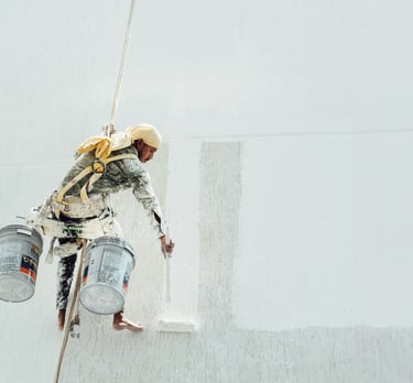 a man in a white shirt painting a wall