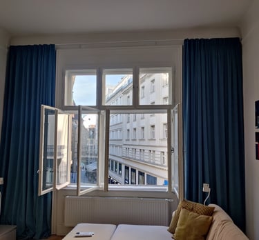 View of Vienna side street through window with velvet curtains