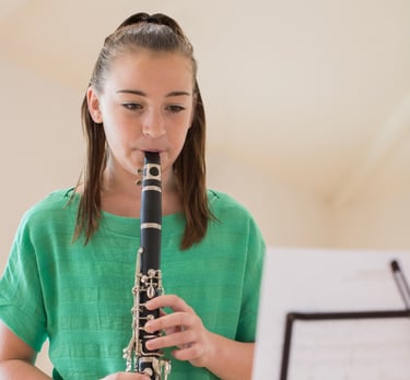 a girl in a green shirt playing a flute