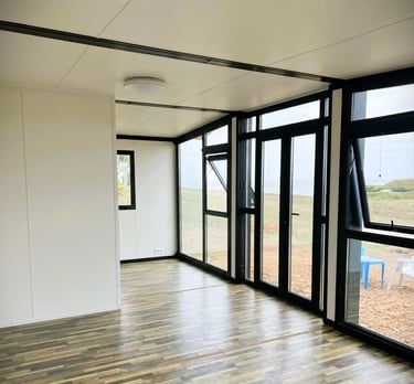 Maison container moderne avec grande façade vitrée lumineuse.