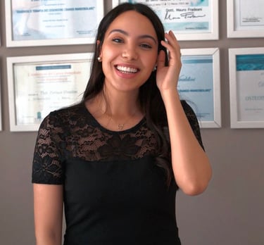 a woman in a black dress smiling and talking on the phone
