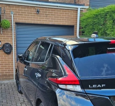 Nissan Leaf parked on a drive in Chesterfield with a newly installed EV charger on the house wall