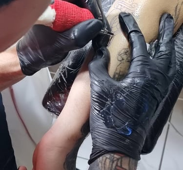 Tatuador chileno realizando tatuaje neotradicional y estilo anime en sesión profesional