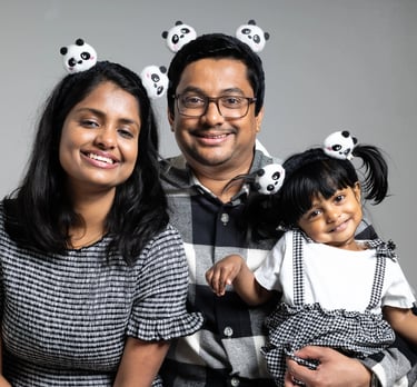a man and woman in panda hats with a little girl