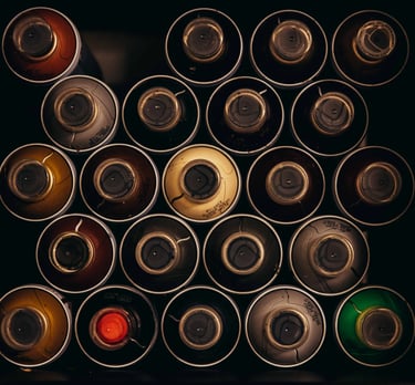 Top-down view of organized colorful spray paint cans in a storage box for graffiti art projects.