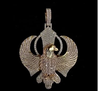a gold - plated pendant with a bird on it