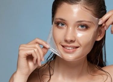 A smiling woman undergoes treatment for radiant facial skin by Dr. Porro.