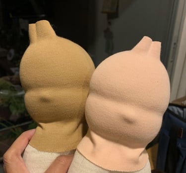 Dos cabezas muñecas Waldorf en proceso hechas a mano en tonos neutros beige y durazno.