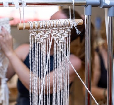  Artesano elaborando un colgante de pared de macramé hecho a mano en un taller creativo.