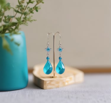Elegant drop earrings with intricate wirework and tiny gemstone accents displayed on a soft linen cloth.