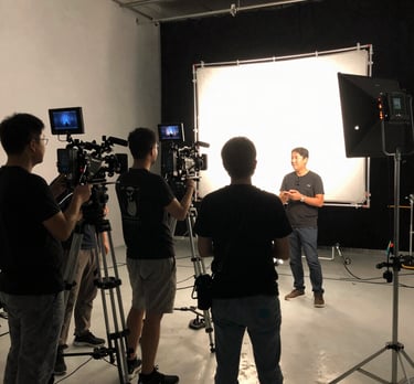 A cinematic close-up of a film set with a director and crew coordinating around a camera and script.